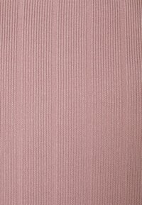 Tissu dans une teinte rose pâle avec une texture côtelée. Le tissu présente des rayures verticales, créant un motif subtil à travers la surface.