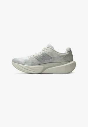 Hellgrauer Sportschuh mit dicker, geformter Sohle und gemustertem Obermaterial, mit einem stilisierten "N"-Logo an der Seite.