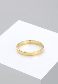 Guld ring med et glat, rundt bånd, der har en poleret finish og et stempel indvendigt. Vist på en simpel hvid overflade.