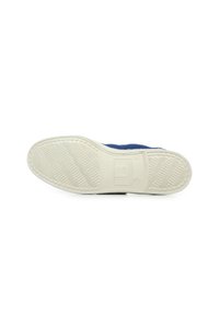 Baskets bleues avec une semelle en caoutchouc texturé, pr�ésentant une semelle extérieure blanche. Comprend un logo imprimé près du talon et un motif de semelle unique.