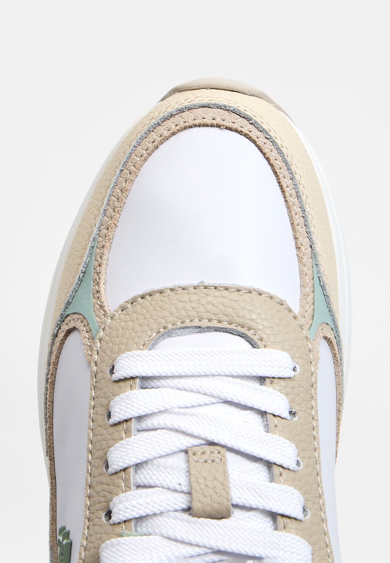 Weißer Sneaker mit beigen Lederakzenten und hellblauen Details. Verfügt über strukturierte Materialien, flache weiße Schnürsenkel und ein rundes Zehendesign.