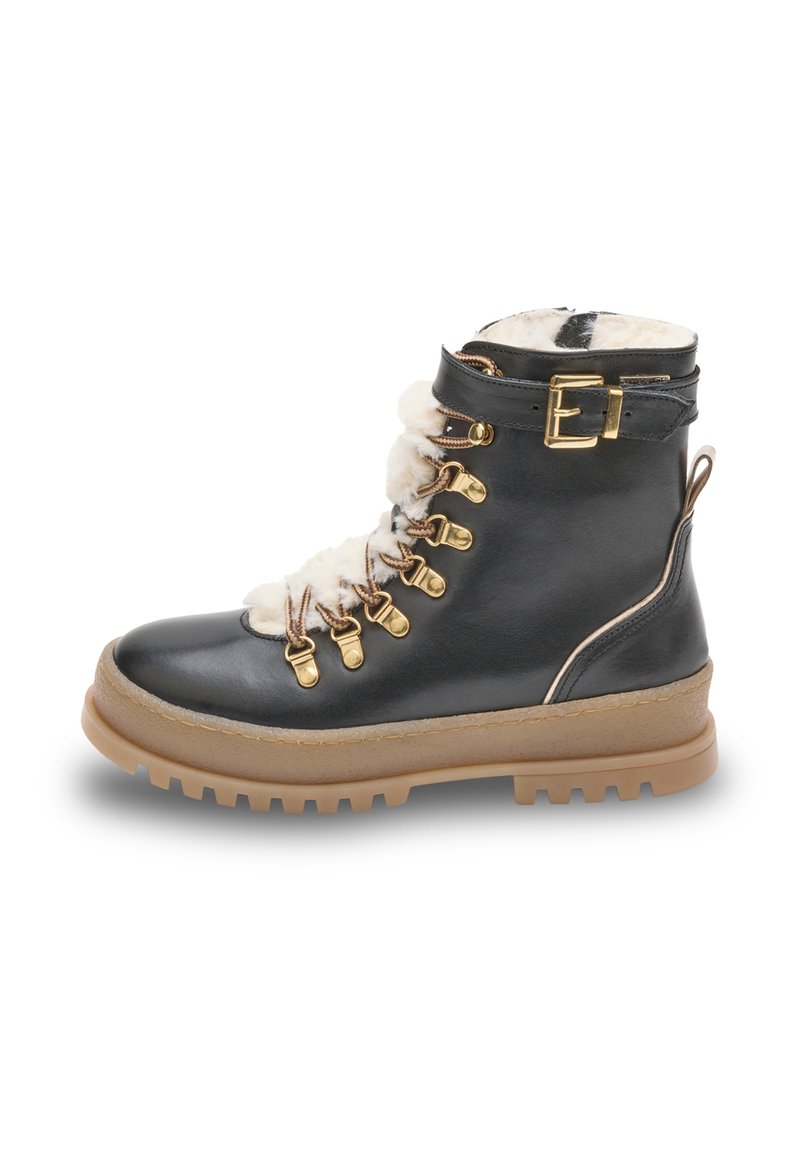 Botín negro de cuero con forro de piel sintética, herrajes en tono dorado y suela de goma marrón. Presenta un cierre de cordones en la parte delantera y un detalle de hebilla en el lateral.