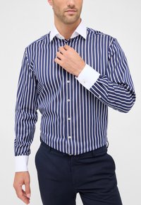 Camicia a righe blu navy e bianca con colletto, patta dei bottoni e dettagli bianchi ai polsi, realizzata in tessuto morbido.