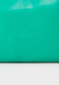 Teal vanntett veske laget av glatt materiale, med preget "RAINS"-logo nederst, minimalistisk design med flat form.