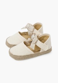 Zapatos de espadrilles beige con parte superior de textil, punta redonda, cinta elástica y detalle de lazo decorativo; suela de yute trenzado natural.