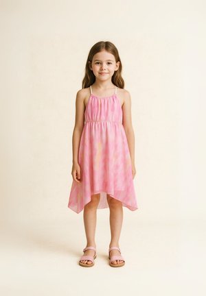 Robe en tie-dye rose avec un ourlet asymétrique, une taille élastique et des bretelles fines. Associée à des sandales roses avec une semelle plate.