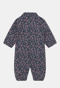 Marinblå overall för baby med långa ärmar, täckt av ett rosa blommönster, med knappar vid kragen och elastiska ärmslut.
