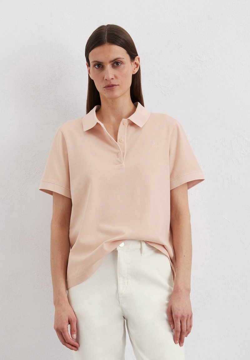Lichtroze polo shirt met een kraag, korte mouwen en een knoopsluiting. Kenmerkt zich door een subtiel logo op de borst en een zachte stofstructuur.