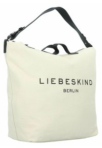 Beige canvas bag with a black leather shoulder strap, featuring "LIEBESKIND BERLIN" printed in bold black letters on the front.