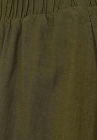 Tissu vert olive à la texture lisse et à la légère brillance, présentant une ceinture froncée et des plis verticaux pour plus de détails.