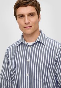 Overhemd met knopen in blauw en witte verticale strepen, voorzien van een kraag, een borstzak en een textuurstof. Standaard pasvorm en klassiek ontwerp.