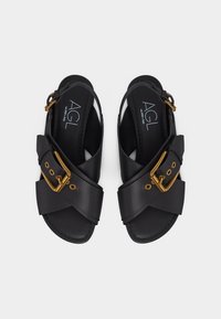 Μαύρα δερμάτινα σανδάλια με φαρδιές διασταυρούμενες λουρίδες, χρυσά αγκράφες και σχεδιασμό slingback, με το λογότυπο AGL στη σόλα.