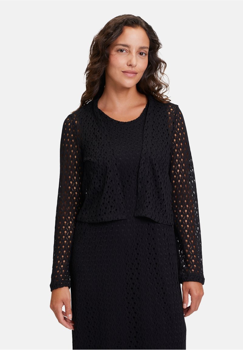 Schwarze Strickjacke mit offenem Vorderteil und langen Ärmeln, die ein strukturiertes Muster aufweist und locker sitzt. Der Stoff ist leicht und atmungsaktiv.