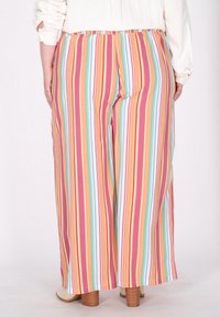 Spodnie z szerokimi nogawkami w wielokolorowe pionowe paski w odcieniach różu, pomarańczu, niebieskiego i białego, z elastycznym pasem i miękkiego materiału.