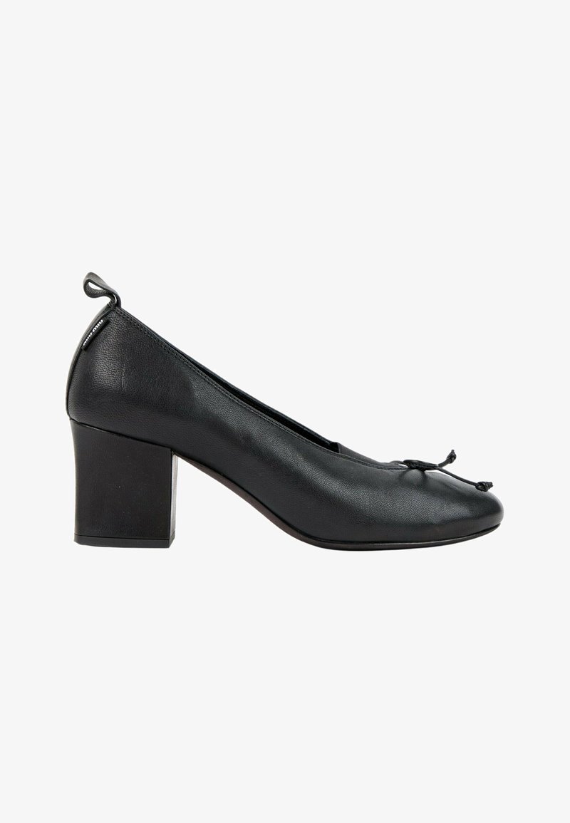 Chaussure en cuir noir à talon bloc bas avec bout arrondi et petit détail nœud sur le dessus, vue de côté sur fond blanc.