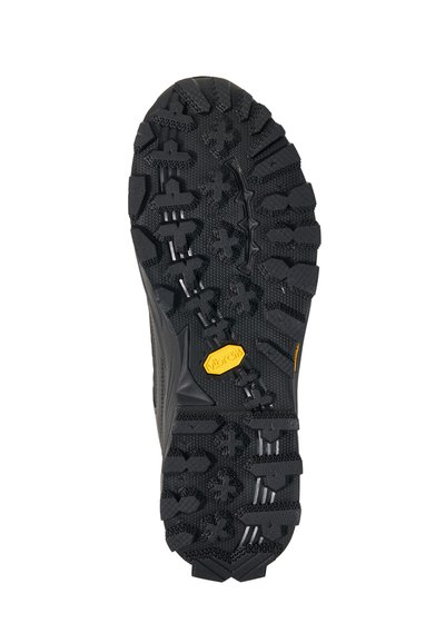 Black rugged boot sole with deep, multidirectional treads and a yellow Vibram logo near the ball of the foot.