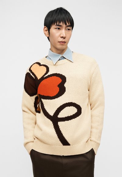 Πλεκτό πουλόβερ σε μπεζ χρώμα με μεγάλο λουλουδένιο σχέδιο σε κόκκινες, πορτοκαλί και καφέ αποχρώσεις. Λαιμόκοψη και μανσέτες με ριμπ, χαλαρή εφαρμογή.