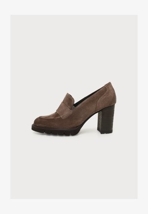 Brun ruskind loafer med høj hæl, kraftig hæl og tyk sål med slidbane, set fra siden mod en hvid baggrund.