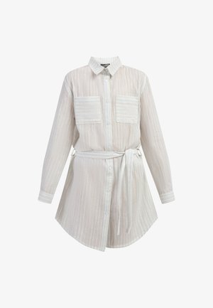 Gombos ing, gallérral, fehér anyagból, függőleges csíkokkal, két elülső zsebbel és deréknál átkötős övvel a szabályozható illeszkedésért.