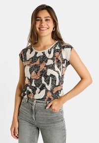 Top negro de manga corta con un patrón abstracto multicolor en beige, rosa y óxido, con cuello redondo y tejido suave.