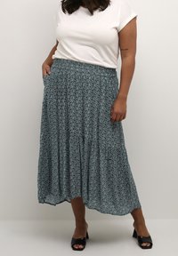 Kwiatowa spódnica maxi w odcieniach zieleni i granatu z warstwowym krojem, elastycznym pasem, bocznymi kieszeniami, lekkim materiałem oraz subtelnym wzorem paisley.