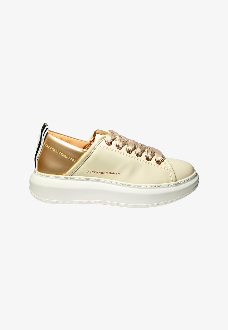 Cremefarvet sneaker med metallisk roseguld accents, rund tå, snørebånd foran, tyk hvid sål og branding på siden.