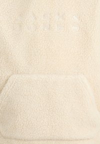 Hoodie en polaire crème avec surface texturée, poche kangourou avant et logo embossé "JACK & JONES" en couleur claire.