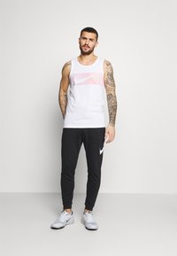 Nike Performance DRY TAPER - Pantalones deportivos - black/white