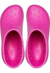 Zuecos de goma rosa con textura de puntos elevados en la superficie superior. Diseño abierto, bordes curvados y plantillas con un patrón para mayor comodidad.