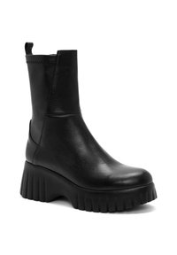 Bottine en cuir noir avec une semelle plateforme épaisse, présentant une texture lisse et des coutures en zigzag en haut.