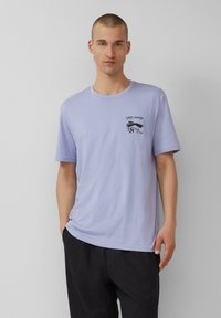Hellblaues Baumwoll-T-Shirt mit Rundhalsausschnitt, kurzen Ärmeln und einem grafischen Druck auf der linken Brust. Schlichte, lockere Passform.