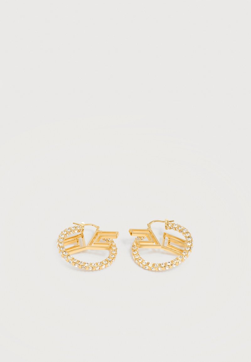 Zlati uhani v obliki obroča z vgrajenimi prozornimi kristali in geometrijskim odprtim kvadratnim dizajnom na svetlo sivi podlagi.