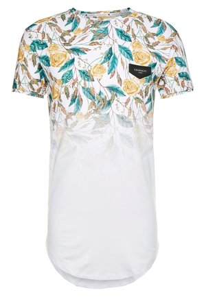 Chemise blanche à manches courtes avec motif floral de rose jaune et feuille verte sur la moitié supérieure et un petit écusson noir du logo Kavanagh sur la poitrine.