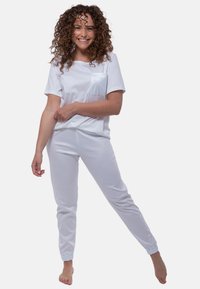 Hvidt bomulds loungewear sæt med en kortærmet top med en brystlomme og tapered bukser med elastiske manchetter. Blød tekstur, afslappet design.