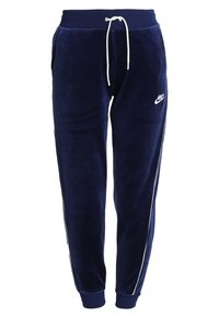 Námořnické modré velurové tepláky s bílou šňůrkou, bočními kapsami a bílými bočními pruhy, s malým logem Nike na stehně.