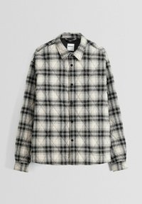 Svart och vit rutig flanellskjorta med knapp-up design, långa ärmar och en quiltad textur. Etikett synlig vid kragen.