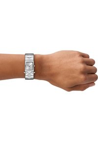 Silberne Edelstahl-Armbanduhr mit rechteckigem Ziffernblatt, klaren Markierungen und einem glatten Band mit wellenförmigen Akzenten.