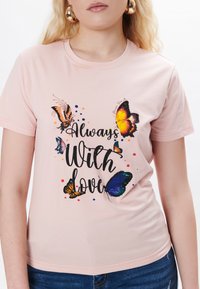 Lyserød kortærmet t-shirt med sommerfugle grafik og teksten "Altid med kærlighed" i sort. Blødt bomuldsstof, tætsiddende design.