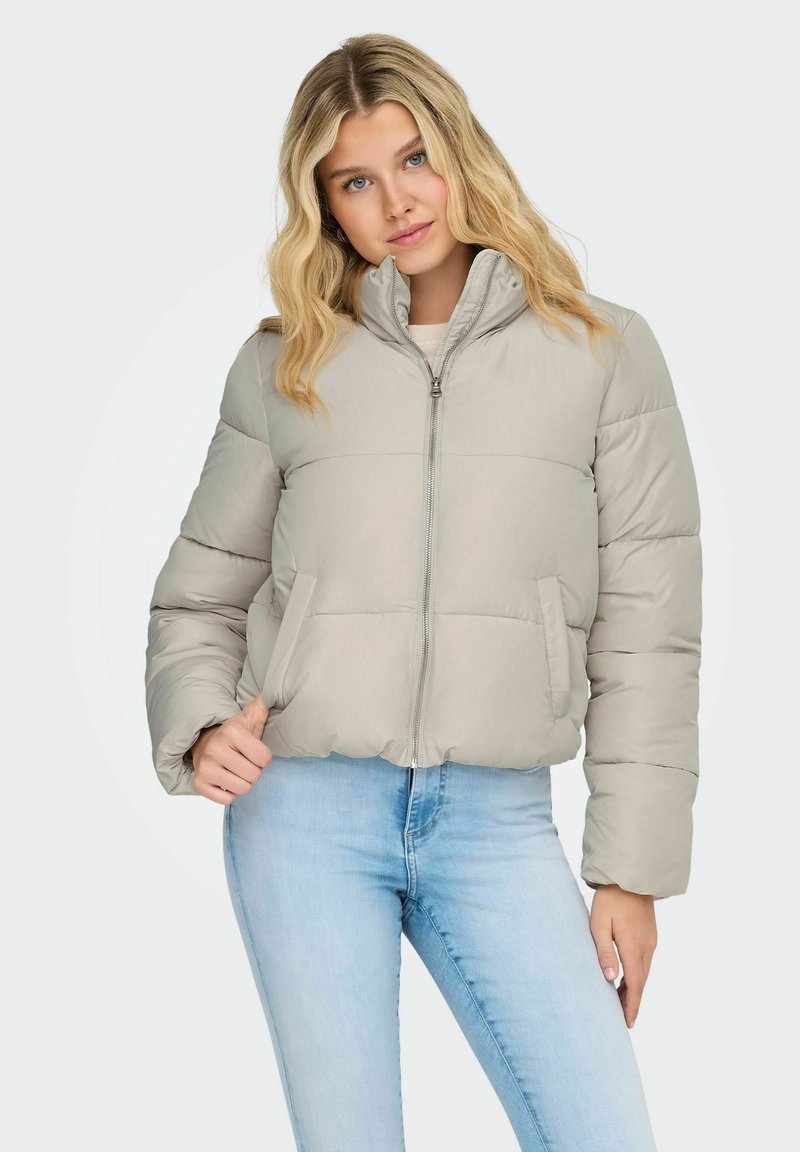 Svijetlosivi puffer kaput s uspravnim ovratnikom, prednjim patentnim zatvaračem i dva bočna džepa. Quilted dizajn s malo skraćenim krojem.