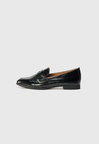 Des mocassins en cuir noir avec un petit talon, une texture lisse et brillante, un bout pointu et une sangle décorative sur le devant.