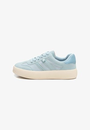 Zapatillas de deporte azul claro con una combinación de materiales lisos y texturizados, que presentan detalles de tres rayas y una suela de goma blanca.