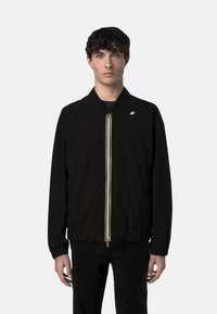 Giubbotto bomber nero con zip frontale, strisce colorate, polsini e orlo a costine, e un piccolo logo sul petto. Materiale leggero.