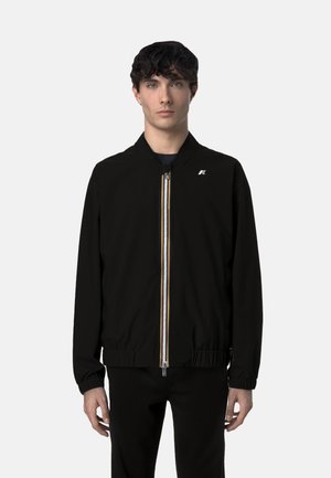 Giubbotto bomber nero con zip frontale, strisce colorate, polsini e orlo a costine, e un piccolo logo sul petto. Materiale leggero.