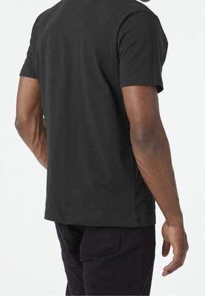 Czarny bawełniany t-shirt z krótkim rękawem, o luźnym kroju i bezszwowym kołnierzem. Tył ukazuje gładką tkaninę i prosty design.