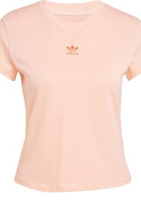 T-shirt à manches courtes et col rond en coton doux couleur pêche. Présente un logo adidas brodé de la même couleur sur la poitrine. Texture lisse.