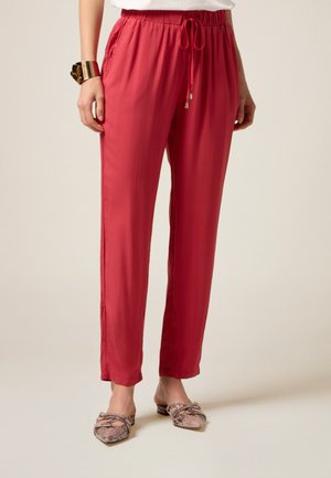 Pantalones rectos ligeros de color rojo, con cintura elástica y cordón, que cuentan con bolsillos laterales y una textura suave.