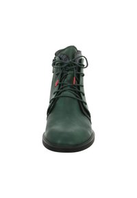 Groene leren enkelboot met gestructureerde zwarte accenten, ronde neus, vetersluiting aan de voorkant en een rits aan de zijkant. Voorzien van rode details.