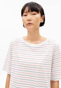 White t-shirt featuring horizontal stripes in red and navy blue. Soft fabric, round neckline, and short sleeves.