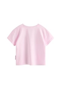 Lyserød kortærmet t-shirt til småbørn med rund hals, let vid pasform, synlige sømme og en lille stofetiket på venstre sidesøm.