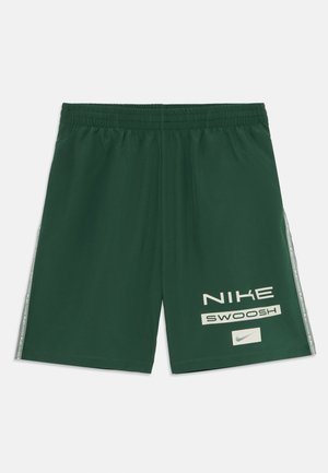 Σκούρο πράσινο σορτσάκι Nike με ελαστική ζώνη, λωρίδες στο πλάι, και λευκό κείμενο και λογότυπο "NIKE SWOOSH" στο αριστερό πόδι.